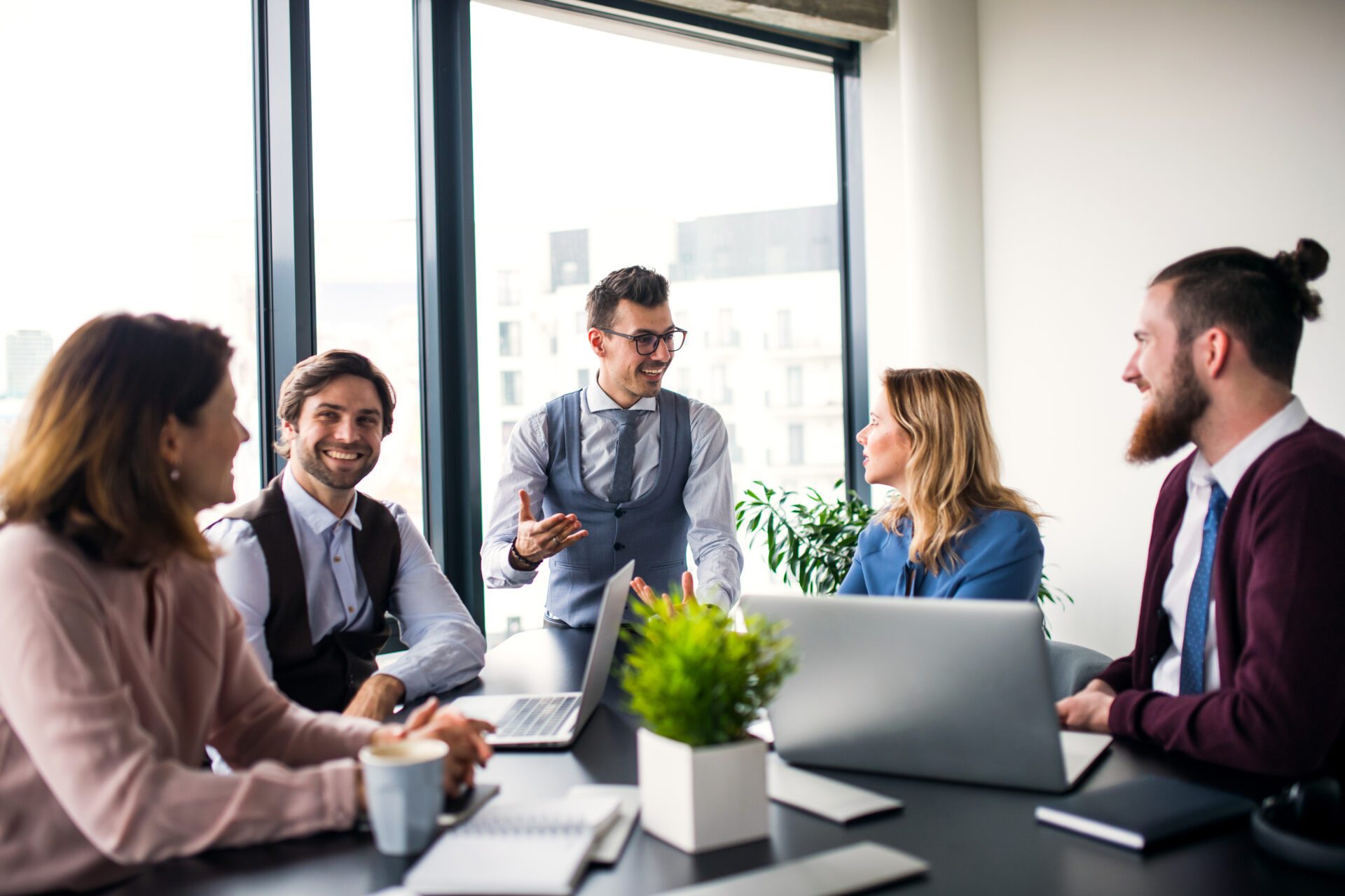 A group of young business people sitting in an office, having meeting. A group of young business people sitting and talking in an office, having meeting.